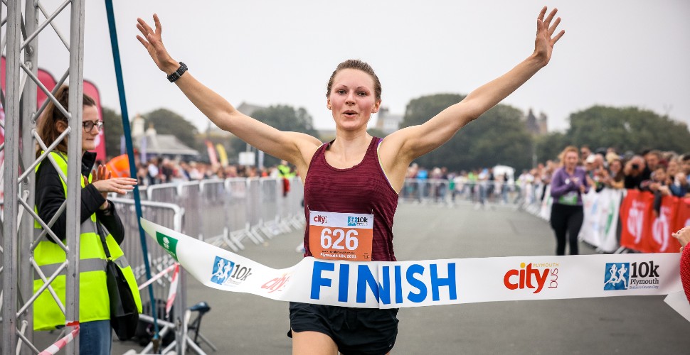 Woman crossing finish line of Britain's Ocean City Half Marathon 